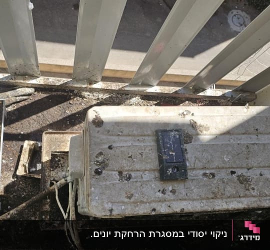 מזגן מלוכלך בלשלשת יונים על מרפסת